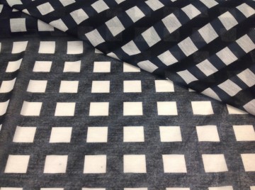 Licht doorzichtige, dunne tricot, zwart met witte blokken. Geschikt voor blouse, tuniek, shawl of bovenlaag van een rokje of jurk